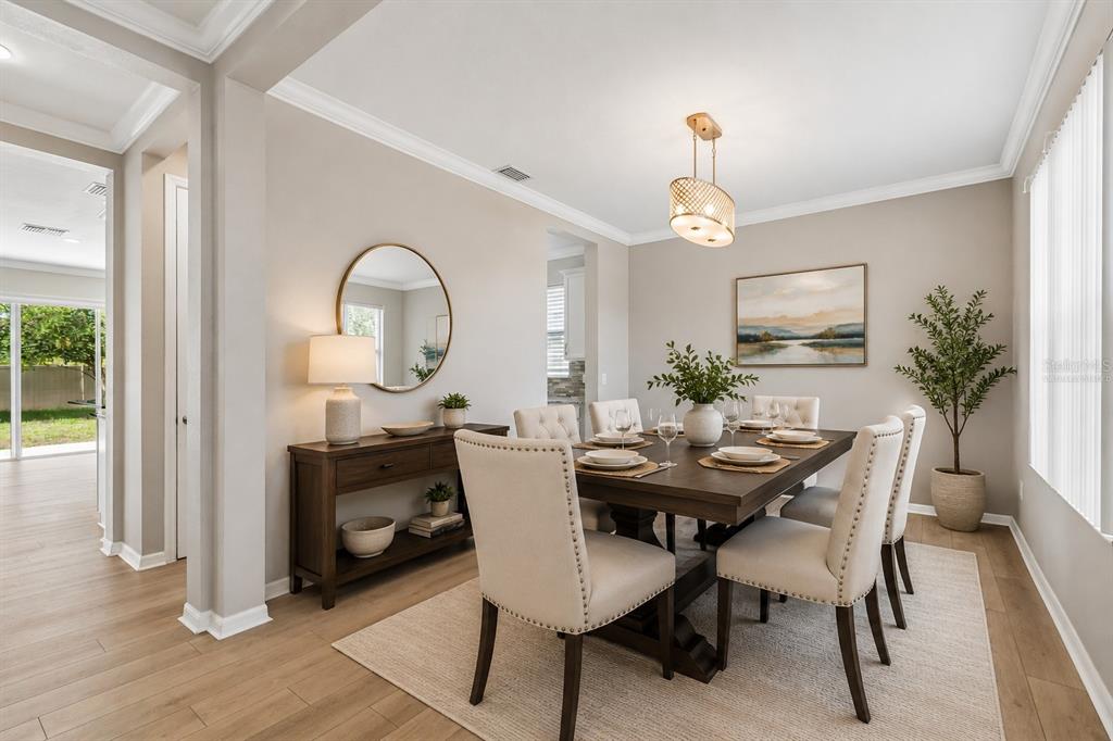1192 Multiflora Loop Lutz, FL 33558 - Photo 8 of 32 a dining room with wooden floor a chandelier a wooden table and chairs
