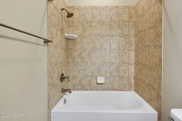 a bathroom with a white bath tub a shower and a sink