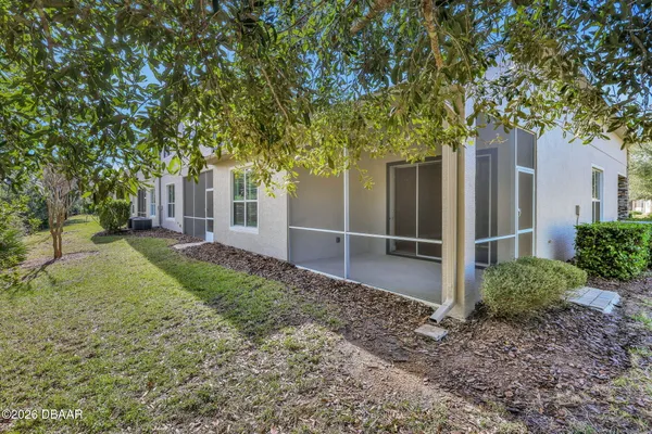 a view of a house with a yard and large trees