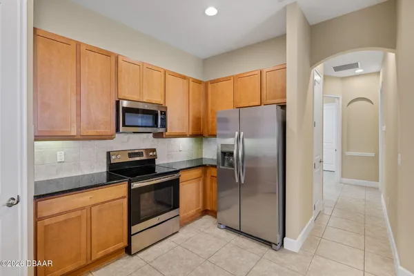 a kitchen with stainless steel appliances granite countertop a refrigerator and a stove top oven