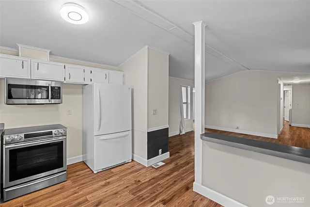 a kitchen with granite countertop a refrigerator and a stove top oven