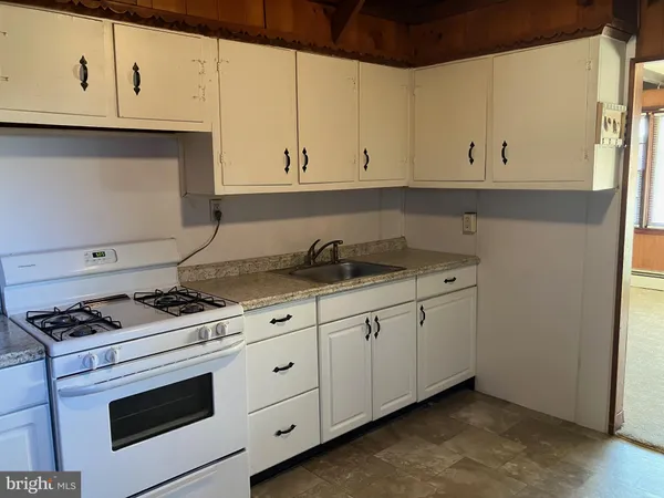 a kitchen with granite countertop white cabinets and white appliances