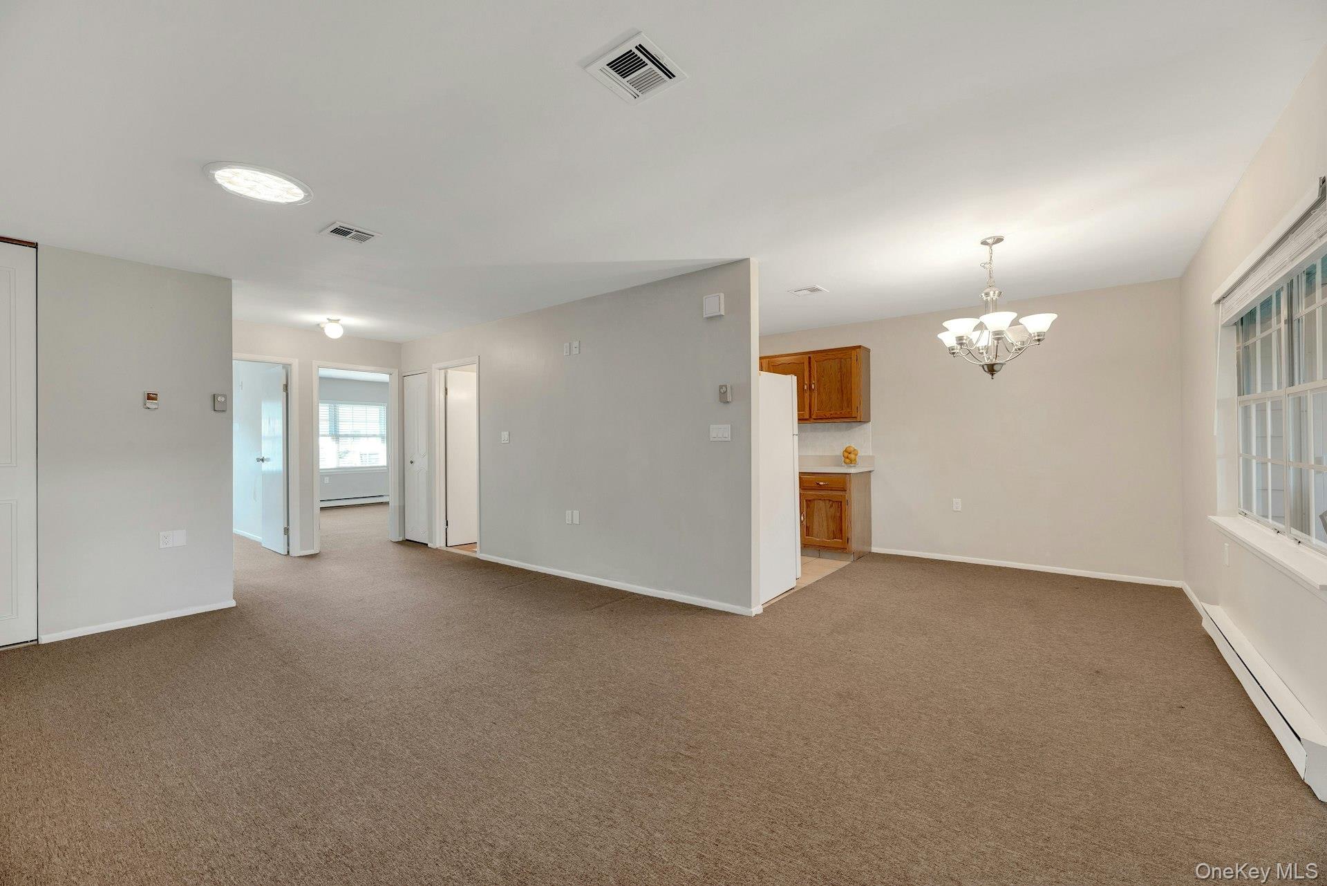 164 Falmouth Court, Unit E Ridge, NY 11961 - Photo 11 of 15 a view of an empty room with a window