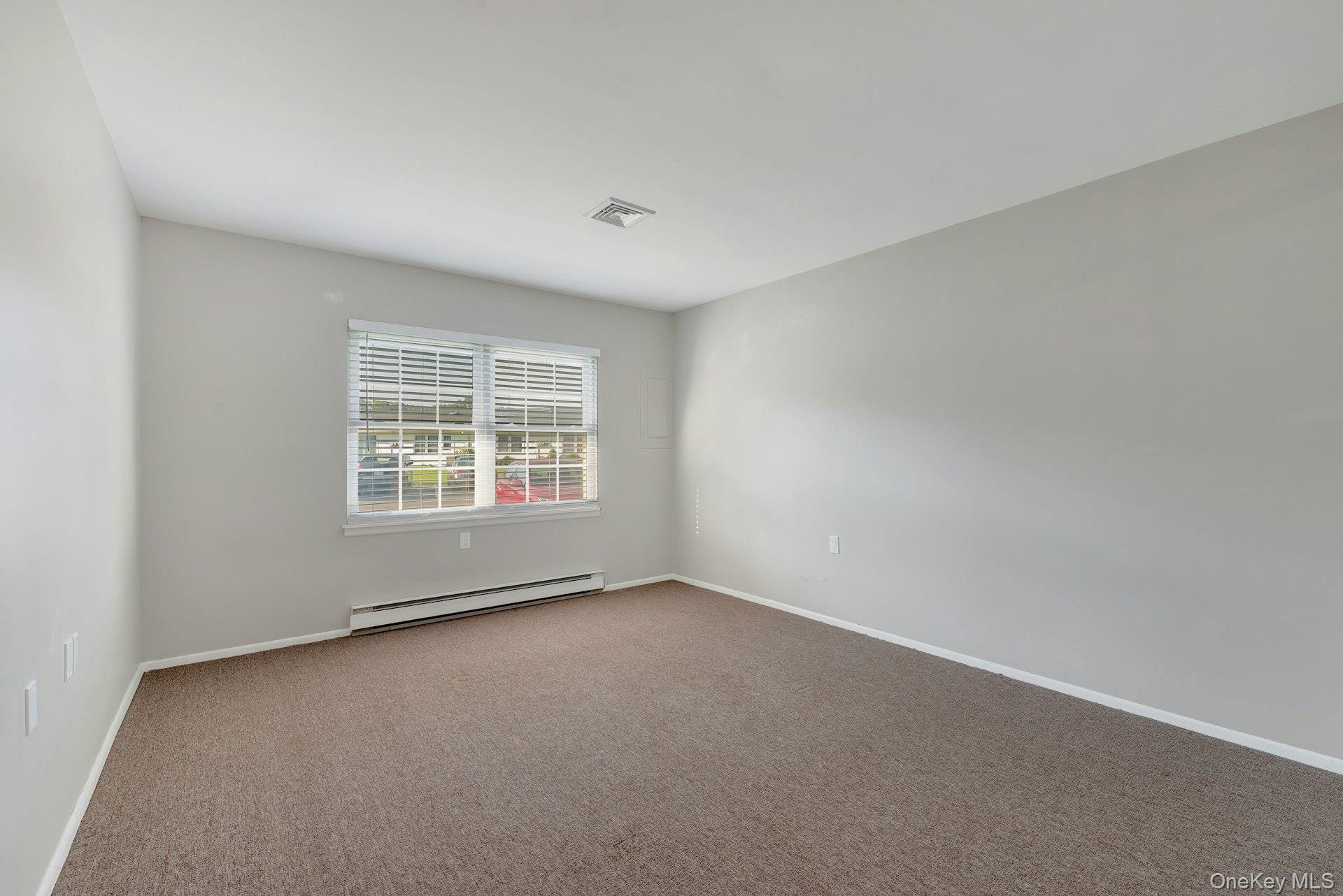 164 Falmouth Court, Unit E Ridge, NY 11961 - Photo 13 of 15 an empty room with windows
