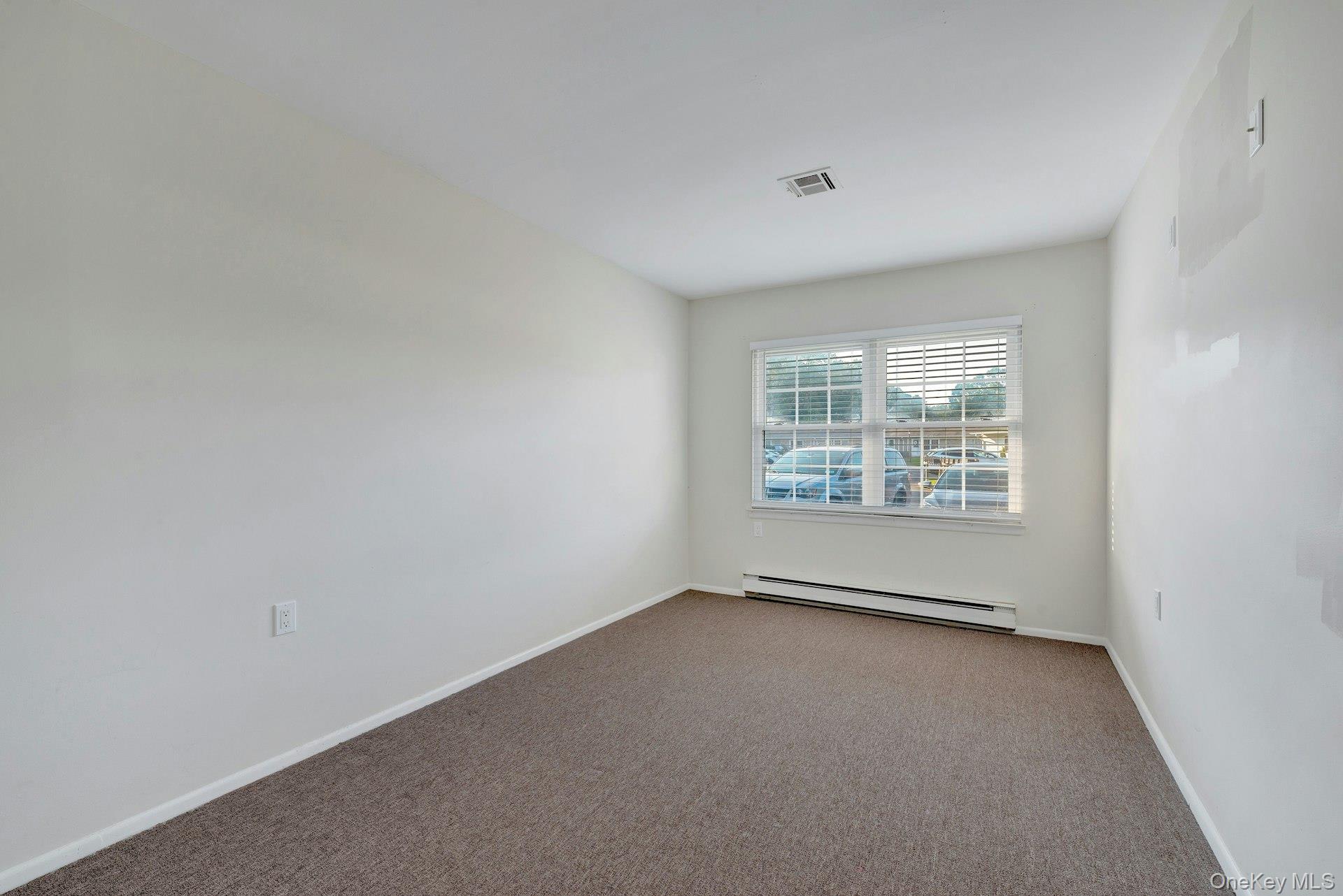 164 Falmouth Court, Unit E Ridge, NY 11961 - Photo 14 of 15 an empty room with windows