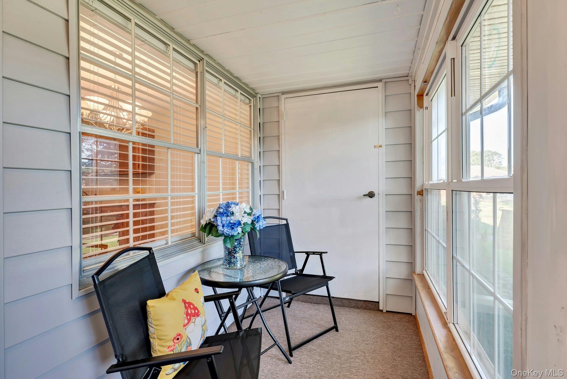 164 Falmouth Court, Unit E Ridge, NY 11961 - Photo 4 of 15 a view of a room with furniture and a window