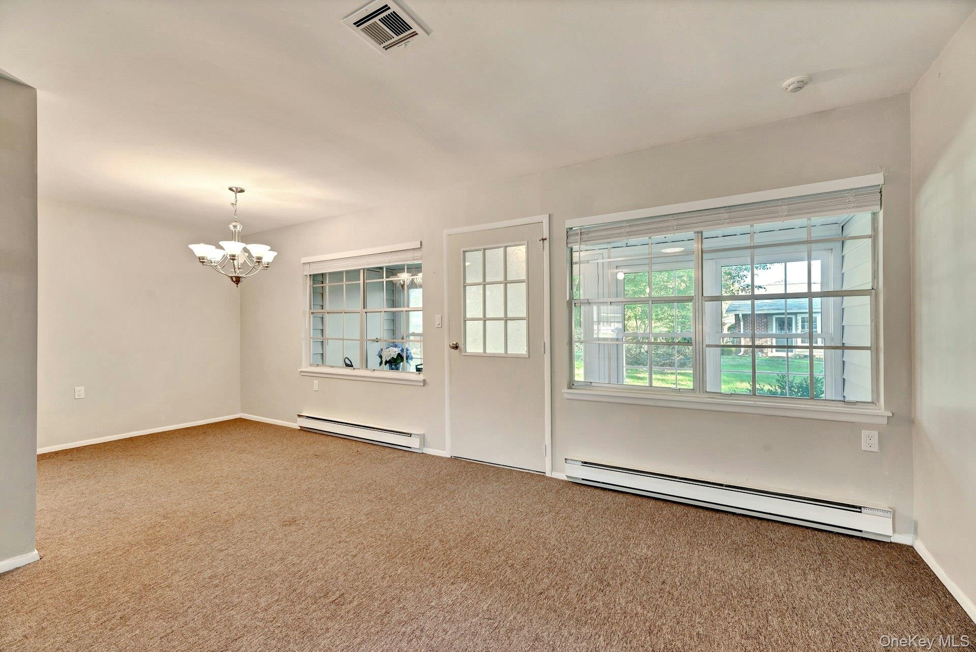 164 Falmouth Court, Unit E Ridge, NY 11961 - Photo 6 of 15 a view of an empty room with a window