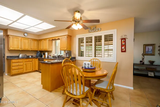 a dining room with stainless steel appliances kitchen island granite countertop a table and chairs