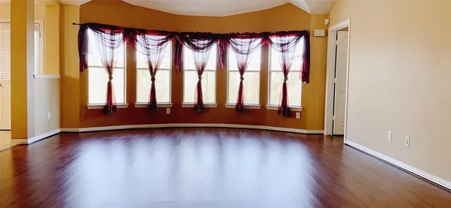 a view of a room with wooden floor and a window