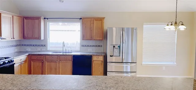 a kitchen with a refrigerator a stove and a window