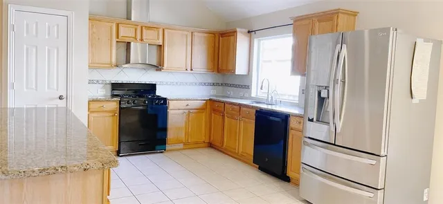 a kitchen with stainless steel appliances granite countertop a refrigerator and a sink
