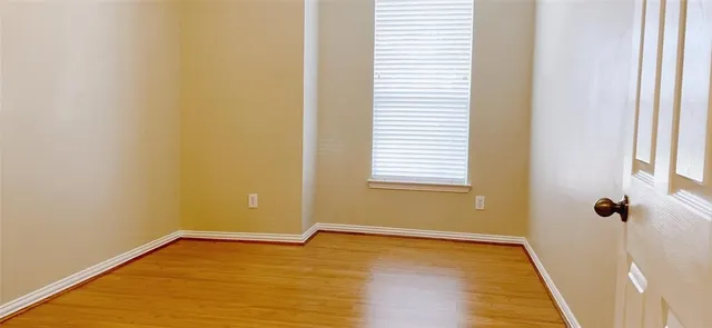 a view of a room that has wooden floor and a window