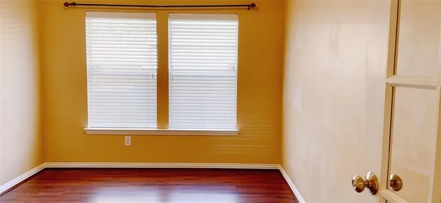a view of front door with hallway and wooden floor