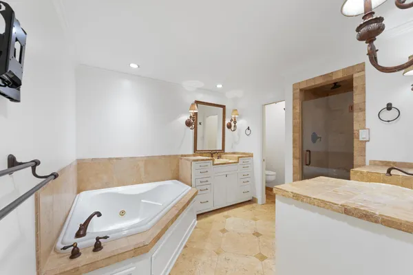 a bathroom with a granite countertop tub sink and mirror