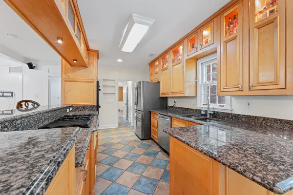 a large kitchen with stainless steel appliances kitchen island granite countertop a sink and cabinets