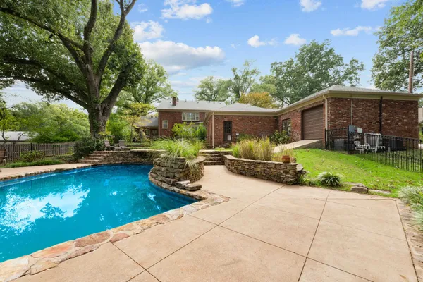 a view of a house with backyard garden and sitting area