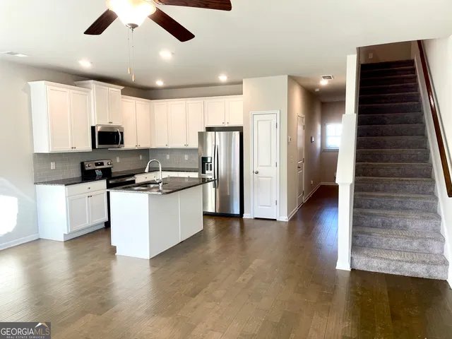 a kitchen with stainless steel appliances kitchen island granite countertop a stove and a refrigerator