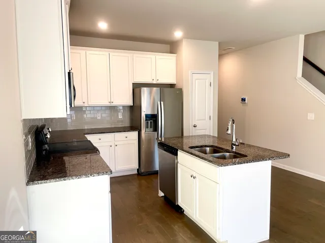 a kitchen with stainless steel appliances granite countertop a sink stove and refrigerator