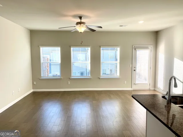 a view of an empty room with window and wooden floor