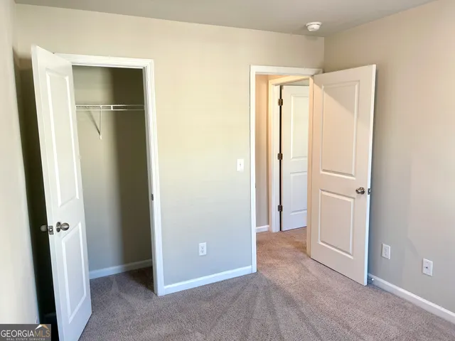 an empty room with closet and wooden floor