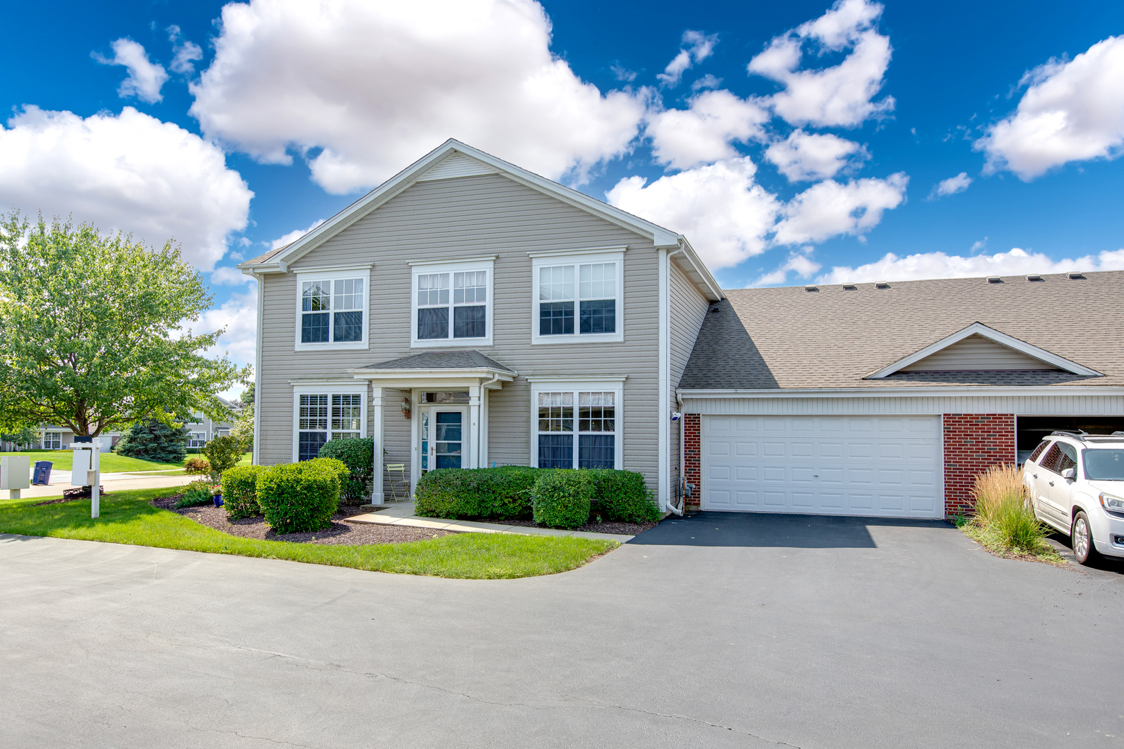 206 Brompton Lane, Unit A Sugar Grove, IL 60554 - Photo 1 of 17 a front view of a house with a yard and garage