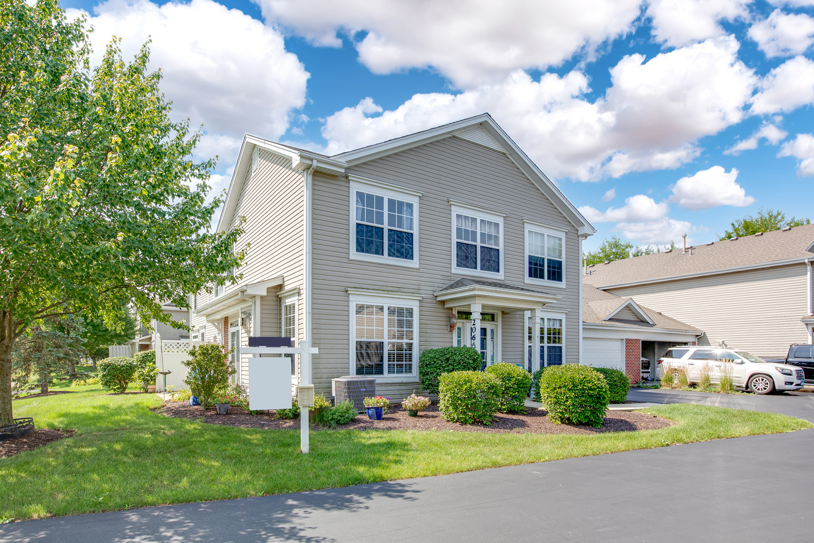 206 Brompton Lane, Unit A Sugar Grove, IL 60554 - Photo 2 of 17 a front view of a house with a yard and garage