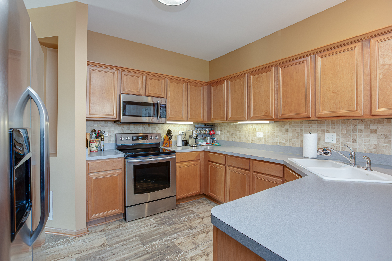 206 Brompton Lane, Unit A Sugar Grove, IL 60554 - Photo 8 of 17 a kitchen with stainless steel appliances granite countertop a stove a sink and a refrigerator