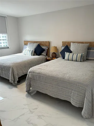 a bedroom with two beds and painting on the wall