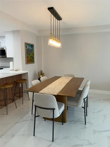 a view of a dining room with a table and chairs