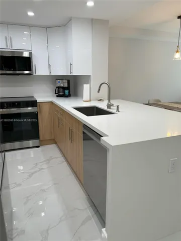 a kitchen with stainless steel appliances a sink dishwasher stove top oven and cabinets