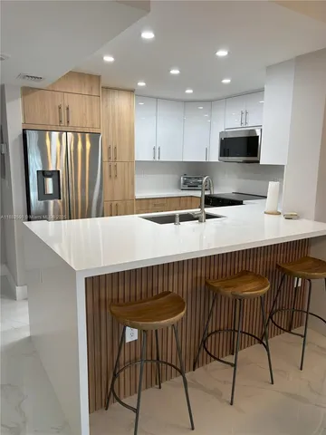 a kitchen with a table chairs refrigerator and microwave