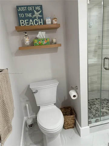 a white toilet sitting next to a bathroom sink
