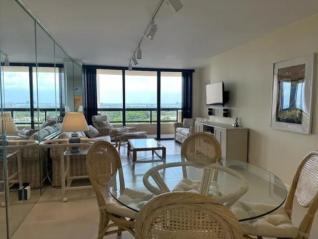 a dining room with furniture a chandelier and window