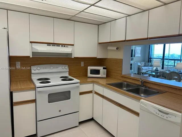 a kitchen with cabinets appliances a sink and a counter top space
