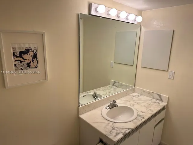 a bathroom with a granite countertop sink and a mirror