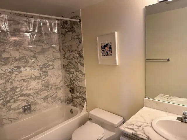 a bathroom with a toilet and a shower curtain