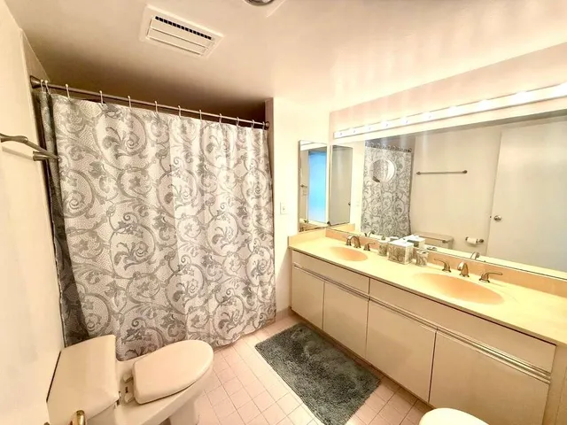 a bathroom with a sink mirror vanity and toilet