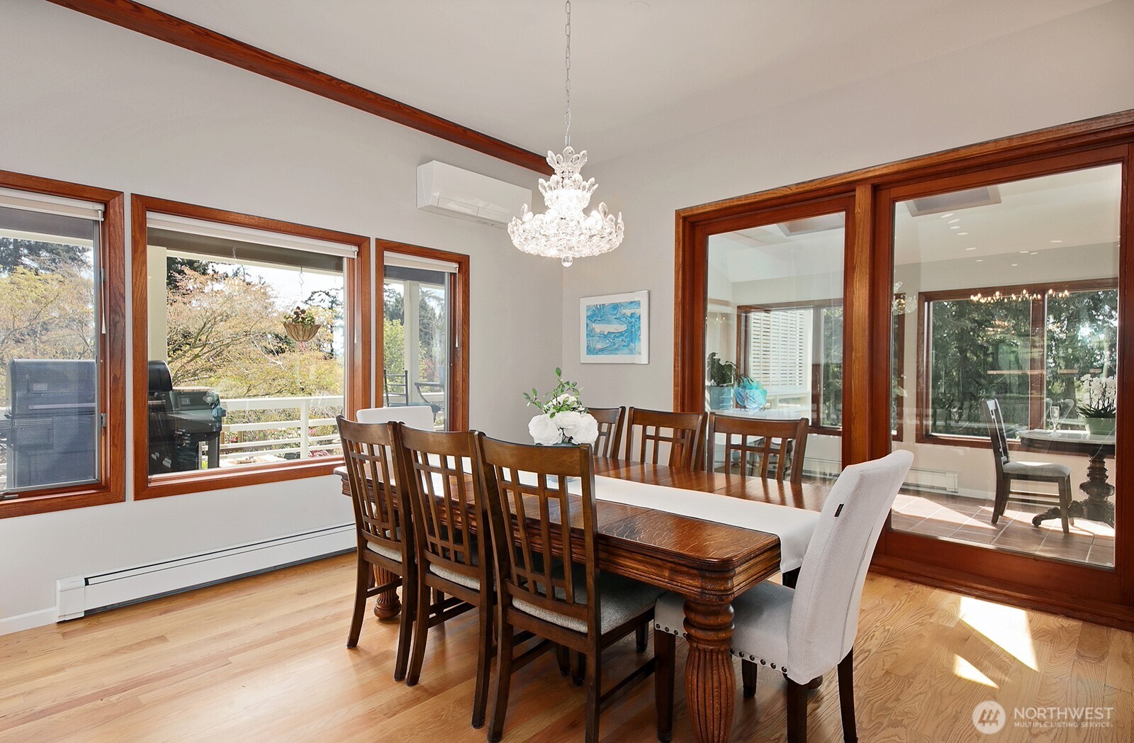 5741 Crow Haven Road Langley, WA 98260 - Photo 24 of 40 a view of a dining room with furniture large windows and wooden floor