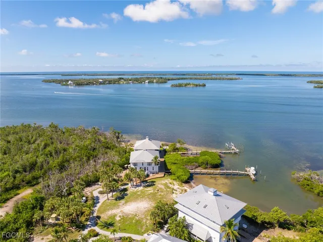 an aerial view of ocean and residential houses with outdoor space
