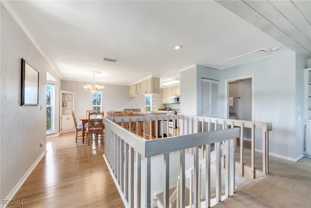 a view of a dining room with furniture a chandelier and wooden floor