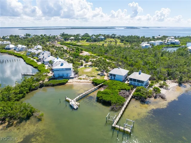 an aerial view of a house with a yard and lake view