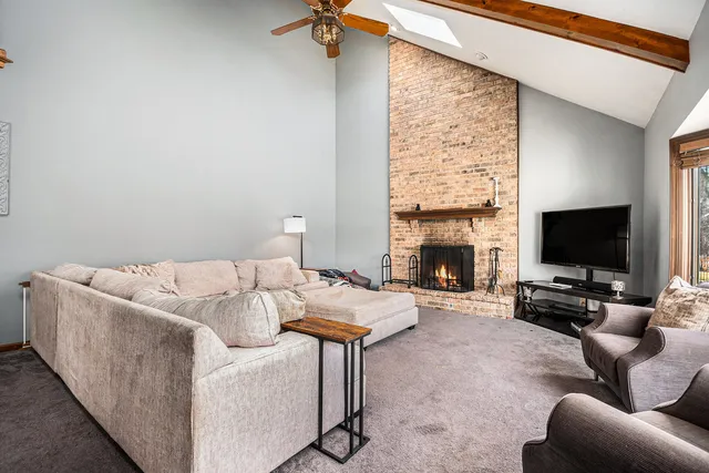 a living room with furniture a flat screen tv and a fireplace
