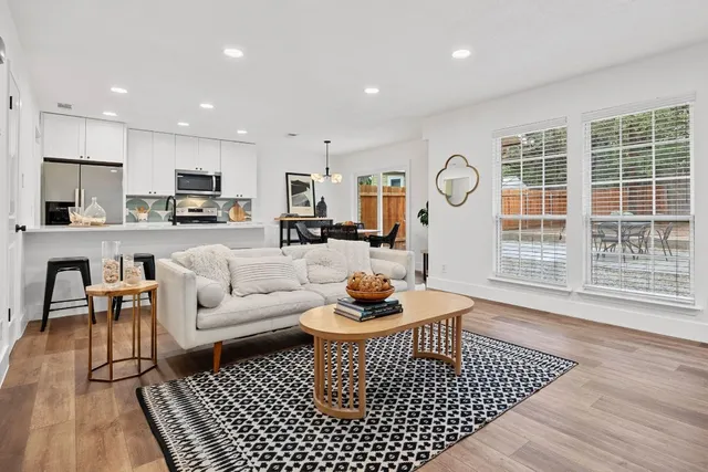 a living room with furniture a rug and a table