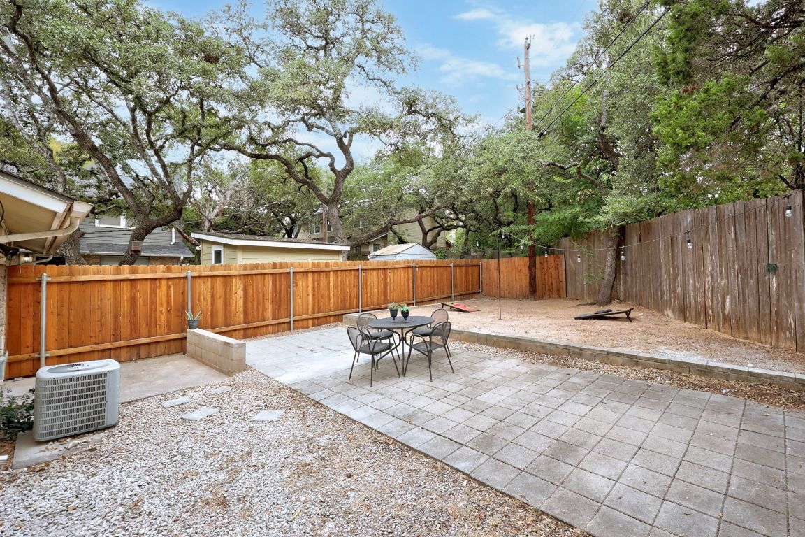 1504 Allen Road, Unit C Austin, TX 78746 - Photo 25 of 26 a backyard of a house with table and chairs