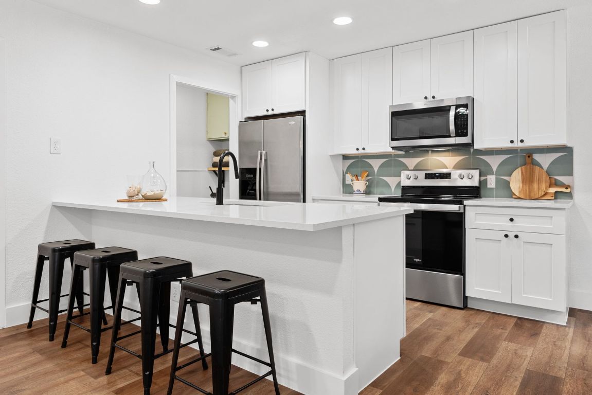 1504 Allen Road, Unit C Austin, TX 78746 - Photo 8 of 26 a kitchen with granite countertop white cabinets and stainless steel appliances
