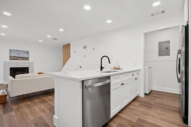 a view of a kitchen with sink dishwasher and wooden floor