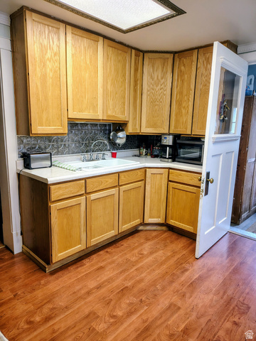 5264 West 5500th Street South Hooper, UT 84315 - Photo 8 of 20 Kitchen featuring light countertops, light wood-type flooring, black microwave, decorative backsplash, and light wood finish cabinets
