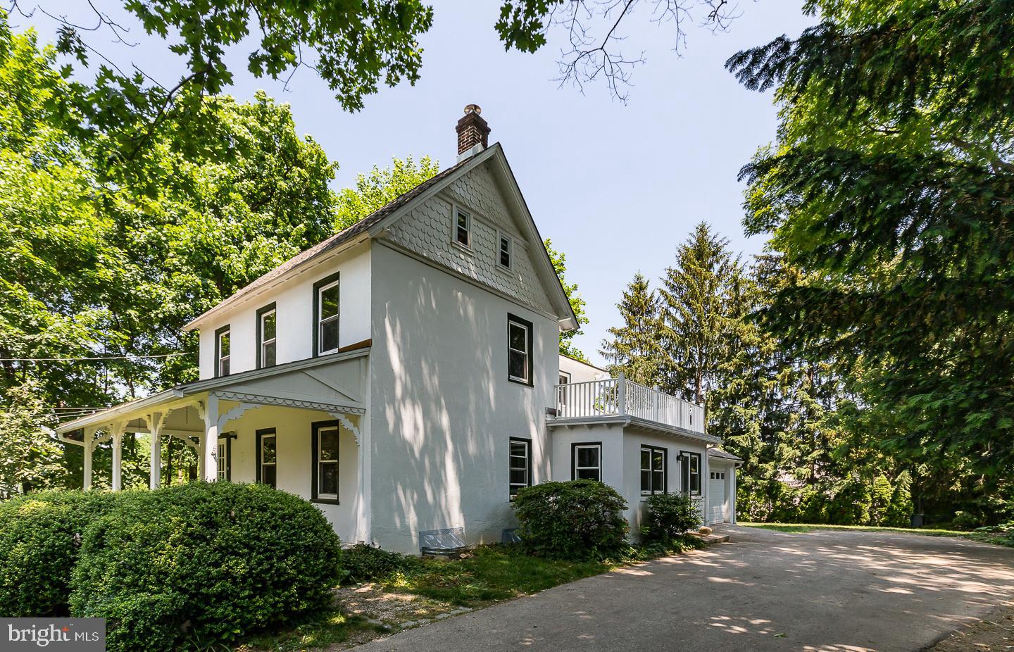 337 Righters Mill Road Gladwyne, PA 19035 - Photo 3 of 41 a view of a white house next to a yard with plants and trees