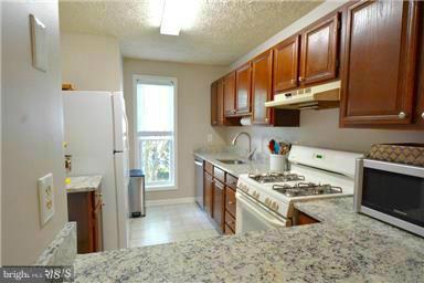 10169 Oakton Terrace Road, Unit 10169 Oakton, VA 22124 - Photo 5 of 14 a kitchen with stainless steel appliances granite countertop a stove a sink and a refrigerator