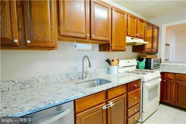 10169 Oakton Terrace Road, Unit 10169 Oakton, VA 22124 - Photo 6 of 14 a kitchen with stainless steel appliances granite countertop a sink a stove and cabinets
